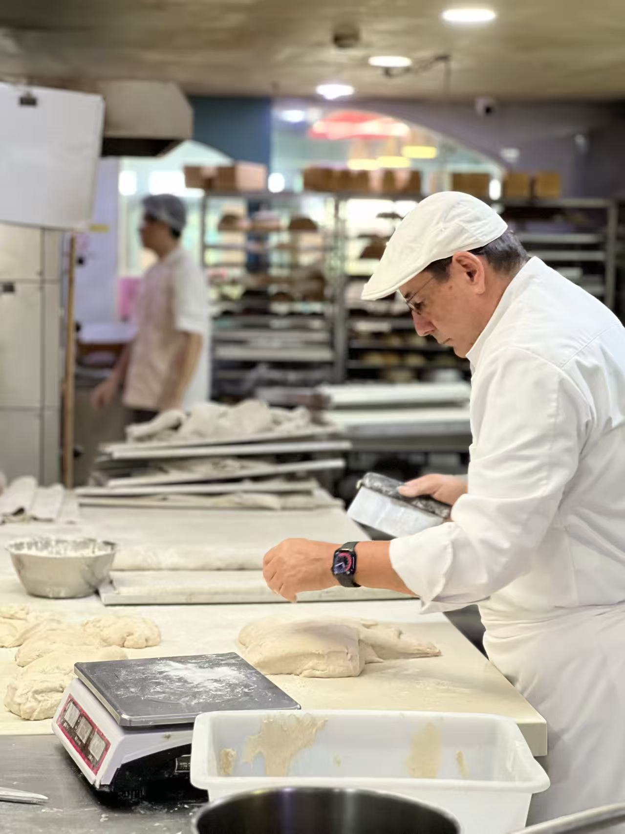 Samy Snoussi façonnant des baguettes devant le four