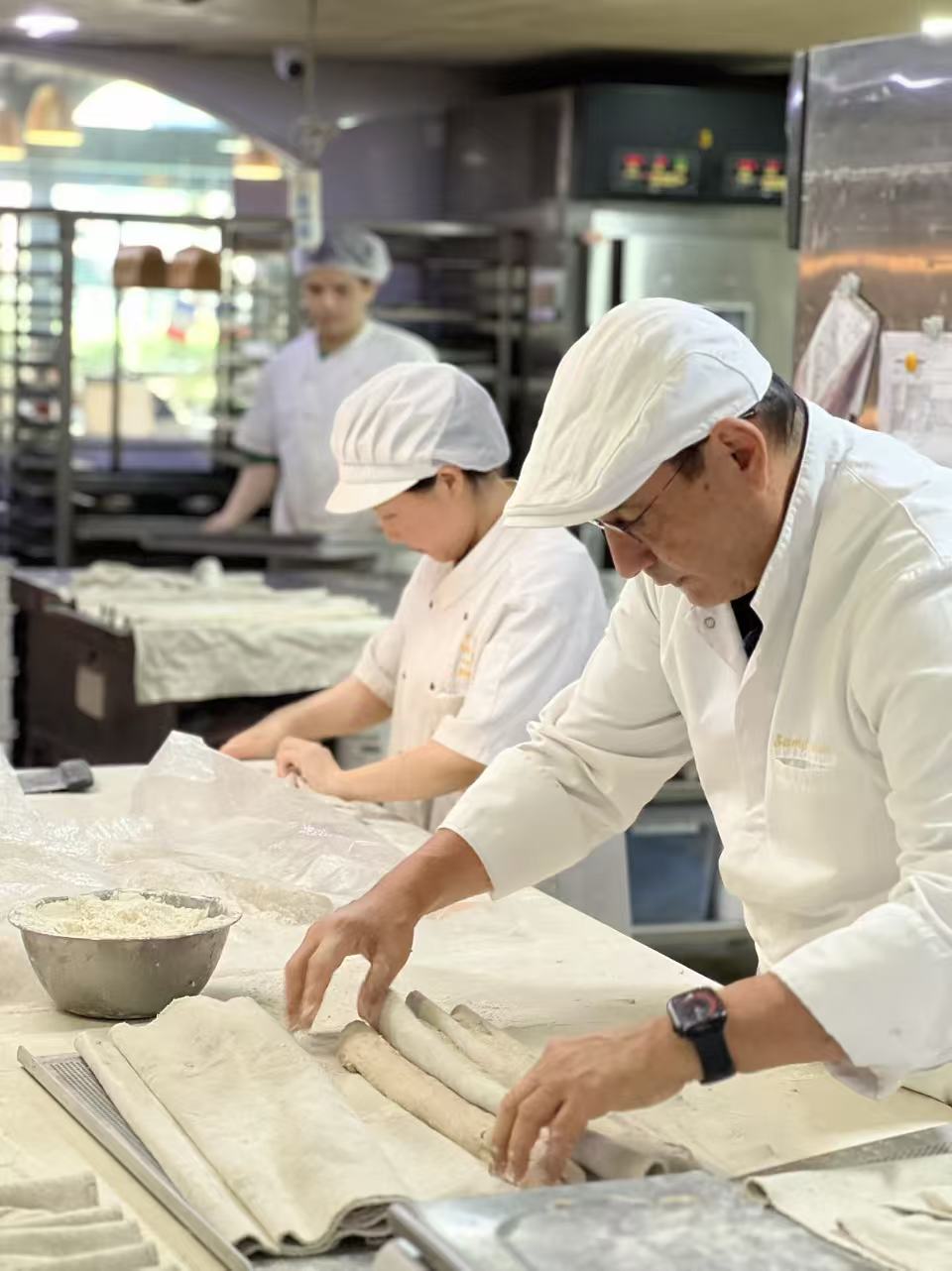 Samy Snoussi au travail en fournil, aux côtés d'une collègue